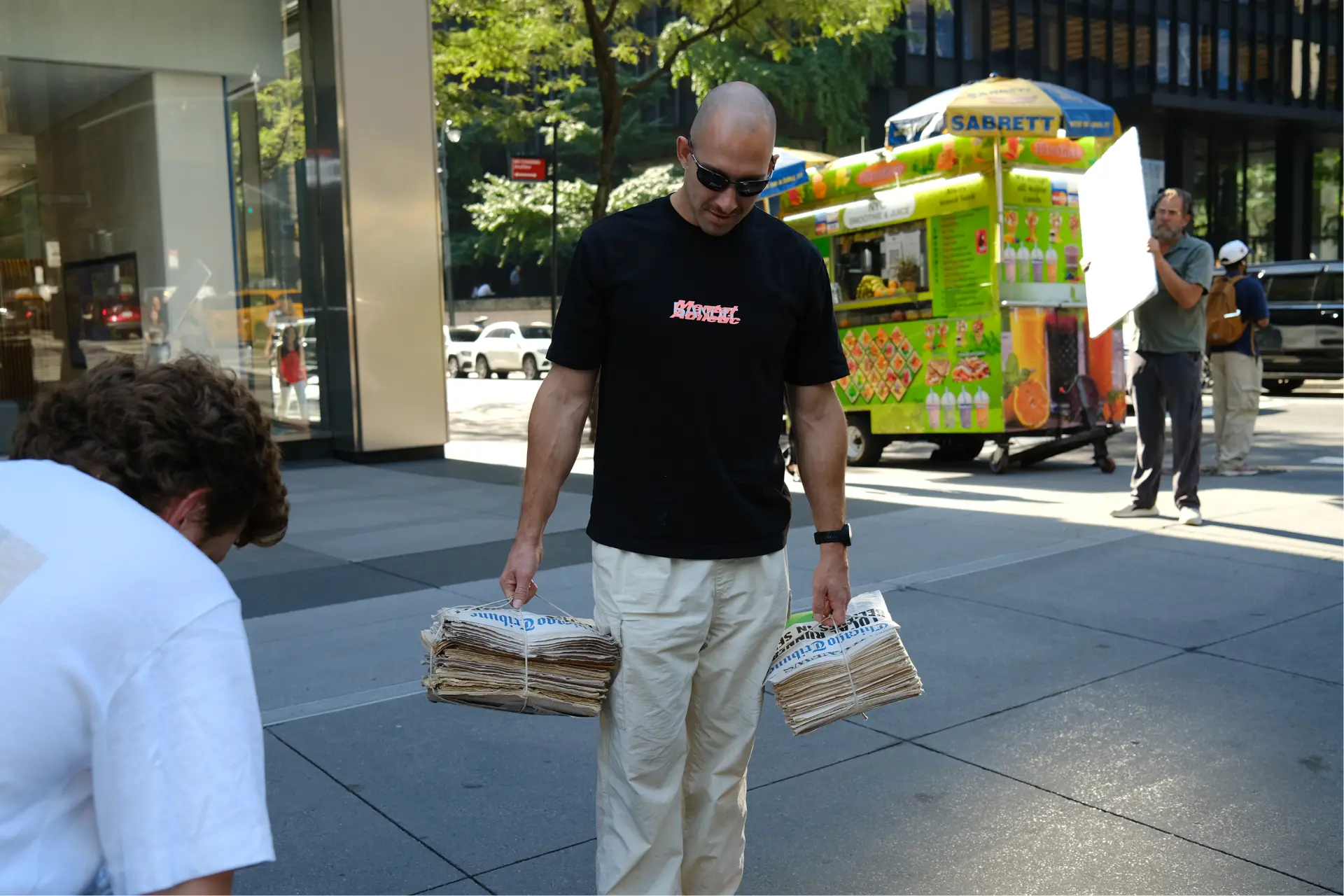 Carrying newspaper bundles down the street