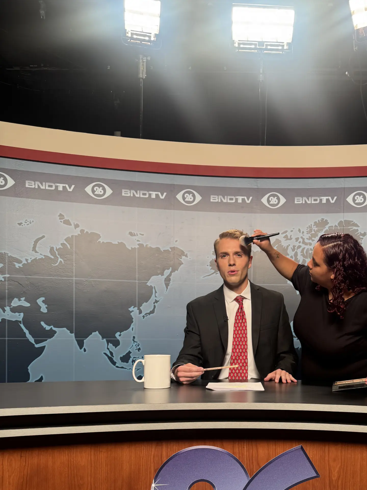 Makeup touch-up for the anchor at the news desk