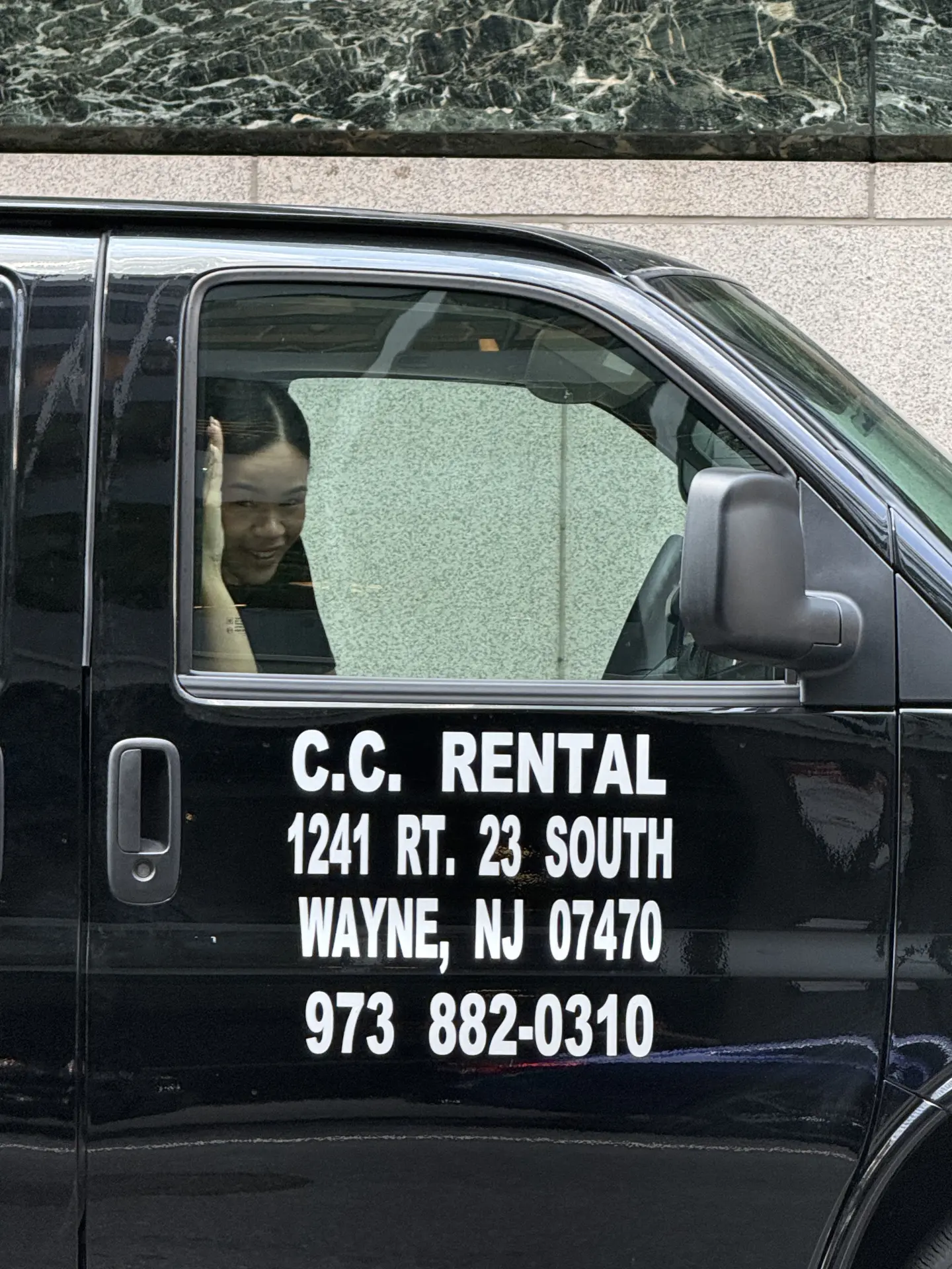 Crew member waving from the rental van