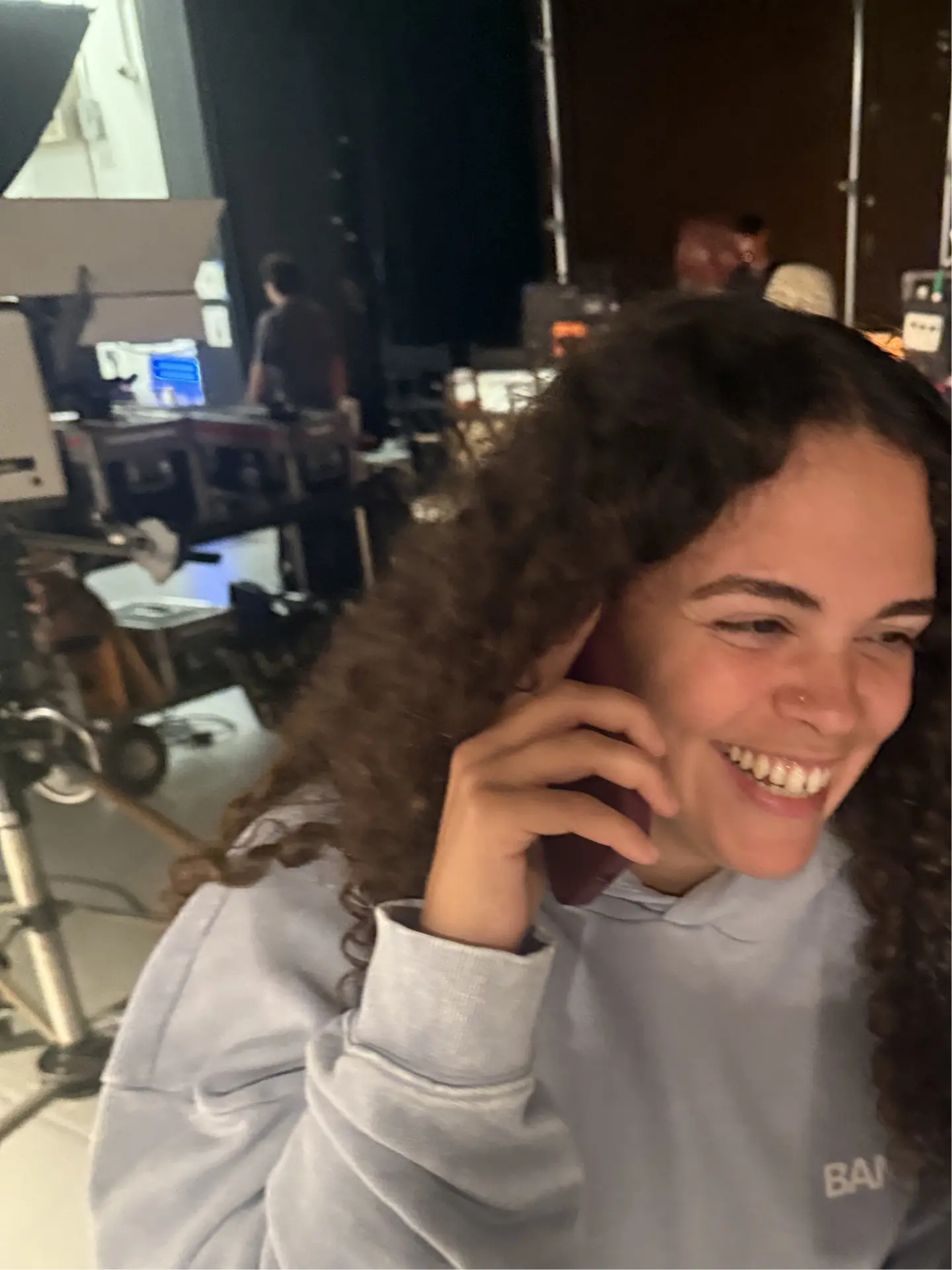 Crew member laughing on the phone in the studio